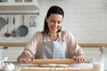 Portrait happy ideal housewife rolling out dough.