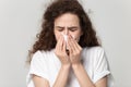 Close up portrait young unhealthy woman wiping runny nose.