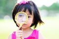 Head shot. Cute Asian child girl looking through gold selling glasses. Kid aged 4-5 years old