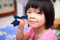 Head shot cute girl smiling. Kid holding navy bow hair accessory. Happy Asian child is black hair. Children aged 4 years old Royalty Free Stock Photo