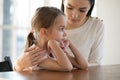 Worried young mother embracing upset little offended daughter.