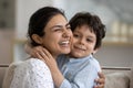 Head shot excited Indian mother hugging adorable 5s son