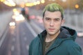 Head shot of handsome green haired guy smiling in the city