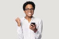 Head shot happy African American girl using phone, celebrating success