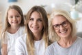 Daughter granddaughter and grandmother looking at camera Royalty Free Stock Photo