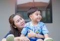 Head shot happy young Asian woman cuddling talking to small kid son