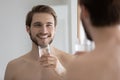 Head shot mirror reflection smiling man holding glass of water