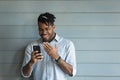 Head shot overjoyed African American man wearing glasses using phone