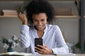 Head shot overjoyed African American woman celebrating success, holding smartphone Royalty Free Stock Photo