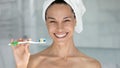 Head shot overjoyed beautiful woman holding toothbrush with toothpaste
