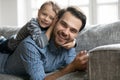 Portrait of adorable little son lying on father`s back. Royalty Free Stock Photo