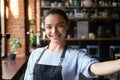 Head shot portrait of attractive smiling waitress in cozy coffeehouse