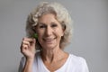 Head shot portrait smiling mature woman holding parsley leaf Royalty Free Stock Photo