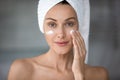 Head shot portrait beautiful woman applying cream on cheekbones