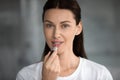 Head shot portrait beautiful woman applying pink lipstick on lips Royalty Free Stock Photo