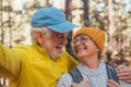 Head shot portrait close up of cute couple of old seniors taking a selfie together in the mountain forest looking at the camera Royalty Free Stock Photo