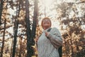 Head shot portrait close up of middle age caucasian woman walking and enjoying nature in the middle of trees in forest. Old mature Royalty Free Stock Photo