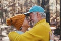 Head shot portrait close up of old people smiling and enjoying looking each other in the forest of mountain. Cute couple of mature