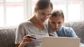 Head shot portrait concentrated young mom with daughter online shopping.