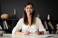 Head shot portrait confident businesswoman looking at camera and talking by headphones. Royalty Free Stock Photo