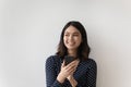 Head shot portrait dreamy smiling Asian woman holding phone