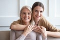 Head shot portrait happy adult daughter hugging older mother