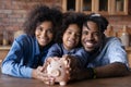 Head shot portrait happy African American family holding piggy bank Royalty Free Stock Photo