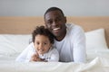 Happy african american millennial guy embracing cute son. Royalty Free Stock Photo