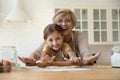 Head shot portrait happy grandmother with granddaughter rolling dough together Royalty Free Stock Photo