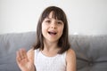 Head shot portrait little girl wave hand looking at camera