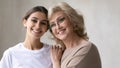 Head shot portrait middle aged mother with adult daughter hugging Royalty Free Stock Photo