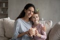 Head shot portrait mother and little daughter holding piggy bank Royalty Free Stock Photo