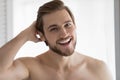 Head shot portrait overjoyed satisfied young man touching hair