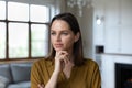 Headshot portrait pensive woman touch chin looking into distance