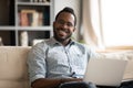 Head shot portrait smiling African American man relaxing with laptop Royalty Free Stock Photo