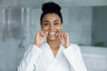 Head shot portrait smiling African American woman using dental floss Royalty Free Stock Photo