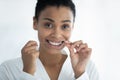 Head shot portrait smiling African American woman using dental floss Royalty Free Stock Photo