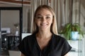 Head shot portrait of smiling businesswoman intern looking at camera