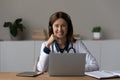 Head shot portrait smiling female doctor in headphones using laptop Royalty Free Stock Photo