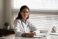 Head shot portrait smiling female doctor filling medical documents Royalty Free Stock Photo