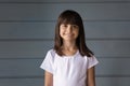 Head shot portrait smiling little girl on grey studio background Royalty Free Stock Photo
