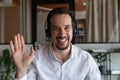 Head shot portrait of smiling man in headphones waving hand Royalty Free Stock Photo