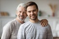 Head shot portrait smiling mature father and adult son hugging Royalty Free Stock Photo