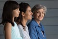 Head shot portrait smiling mature woman with daughter and granddaughter