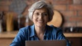 Head shot portrait smiling mature woman wearing glasses using laptop Royalty Free Stock Photo