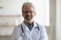 Head shot portrait of smiling older male general practitioner.