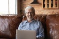 Head shot portrait smiling senior man in glasses using laptop Royalty Free Stock Photo