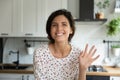 Head shot portrait of smiling woman waving hand at camera Royalty Free Stock Photo