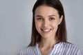 Head shot portrait of smiling young woman on grey background Royalty Free Stock Photo