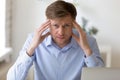 Head shot portrait of thoughtful businessman touching temples Royalty Free Stock Photo